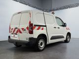 the white van is parked in a large room with a red and white stripe on the side of the van