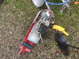 a bird that is standing on the ground next to a lawn mower