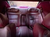 the back seats of a car with leather seats and a pink seat belt