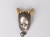 a small metal object with horns on a white surface