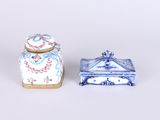 paire de boîtes en porcelaine bleue et blanche avec couvercles, posées sur un support blanc