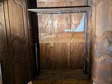 an old wooden bed in a room with two doors open
