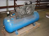 a blue air compressor sitting on a pallet in a warehouse