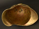 an antique brass helmet on a black background
