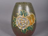 a brown vase with a rose design on it