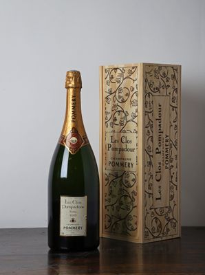 La bouteille de champagne se trouve à côté d'une boîte en bois, posée sur une table.