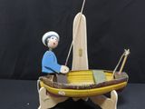 a small wooden toy boat with a man in it