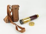 an old telescope with a leather case next to it