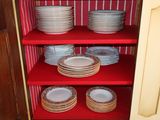 a red cabinet with plates and bowls on it