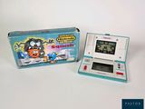 a small electronic game with a box on the table