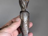 someone is holding a knife in their hand with a pattern on it