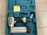 un gros plan d'une boîte à outils contenant un pistolet à clous