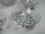 four clear glass bowls sitting on top of a white table