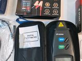 many items that are on a table that include a battery tester, a game controller, a game controller, and a case