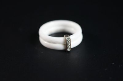 un gros plan d'une bague blanche sertie d'un diamant