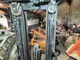 a forklift in a warehouse with other machinery in the background