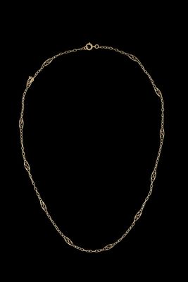 un collier en or dont la chaîne est mise en valeur sur un fond noir