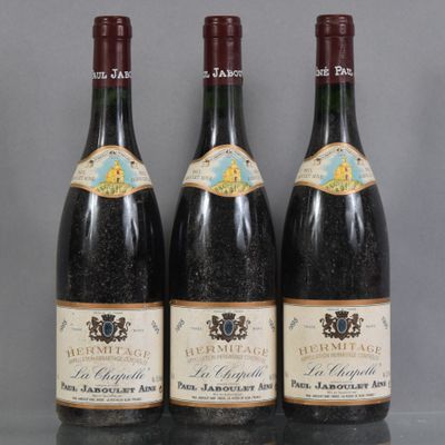 three bottles of wine are lined up on a table