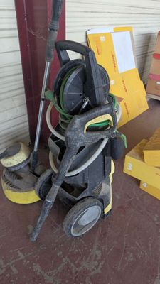 une pile de cartons et un aspirateur posés par terre