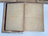 three old books sitting on a table with writing on them