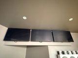 three televisions mounted on the wall above a stove