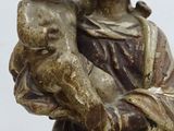 an old statue of a woman holding a child in her arms
