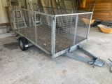 une remorque équipée d'une cage à l'arrière, dans un garage