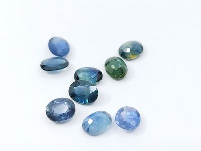 a group of blue and green gems sitting on top of a white surface