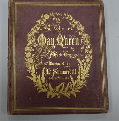 an old book with gold lettering on it sitting on a table