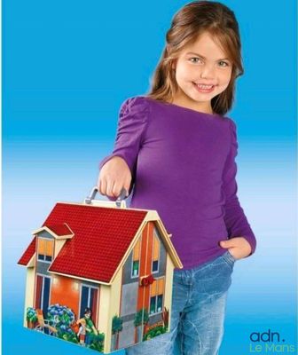 the little girl is holding a toy house in her hand