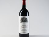 a bottle of red wine sitting on top of a white table