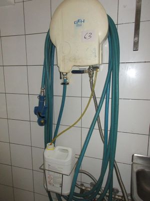 des toilettes équipées d'un tuyau dans une salle de bains