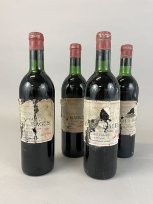 quatre bouteilles de vin sont alignées sur une surface blanche