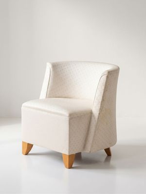 un fauteuil rembourré dans une pièce blanche aux murs blancs
