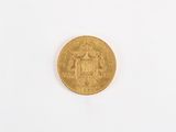 a close up of a gold coin on a white surface
