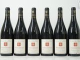 six bouteilles de vin sont alignées sur une table