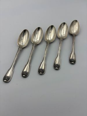 six cuillères en argent sont alignées sur une table