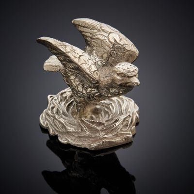 une image représentant une statue en argent d'un oiseau perché sur un nid