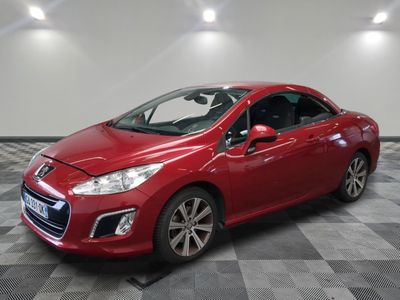 a red car is parked in a room with a checkered floor