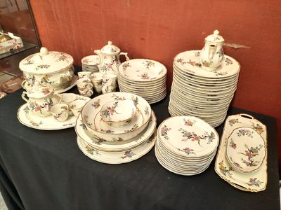de nombreuses assiettes et tasses sur une table recouverte d'une nappe noire