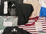 a lot of clothes that are sitting on a bed