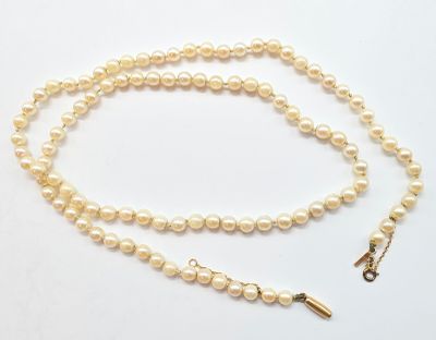 gros plan d'un collier de perles sur fond blanc