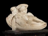 a statue of a woman laying on top of a table