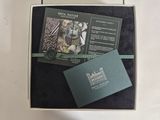 a box with a watch and a business card in it