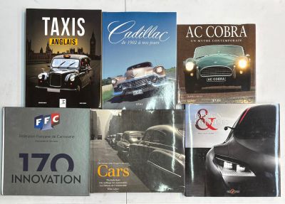 plusieurs livres posés sur une table blanche, avec une voiture en arrière-plan