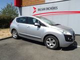 une petite voiture argentée garée devant un immeuble