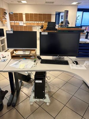 a desk with two monitors and a keyboard on it