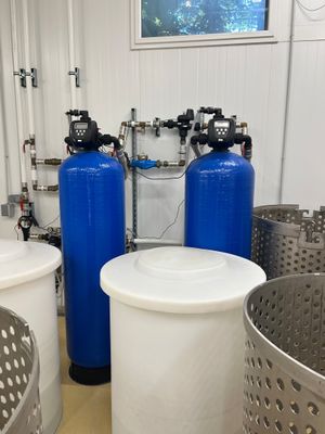 three blue tanks and a white container in the middle of a room