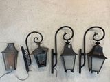 Trois lampadaires à l'ancienne sont accrochés en rangée sur un mur