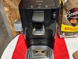 a coffee maker sitting on top of a table next to a bag of coffee
